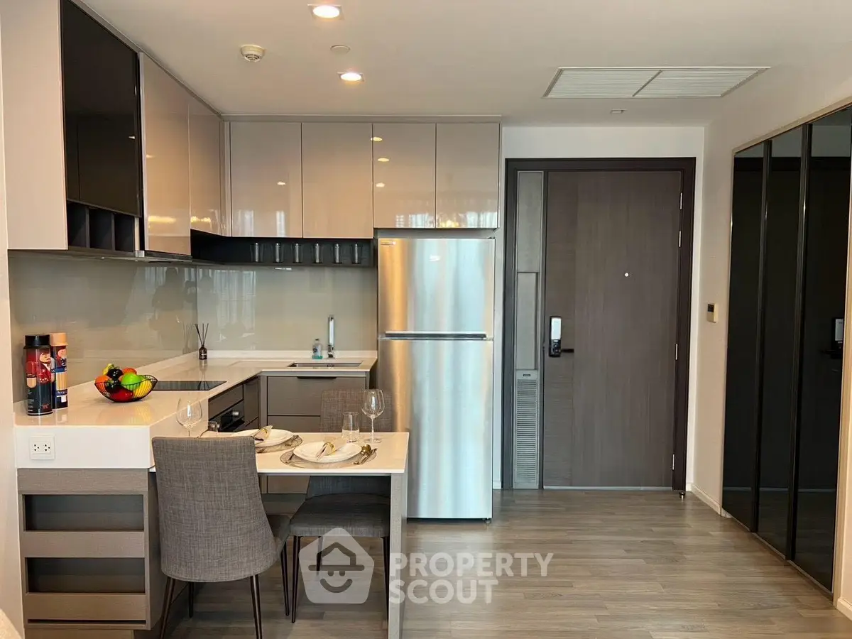 Modern kitchen with sleek design, stainless steel appliances, and cozy dining area in a stylish apartment.