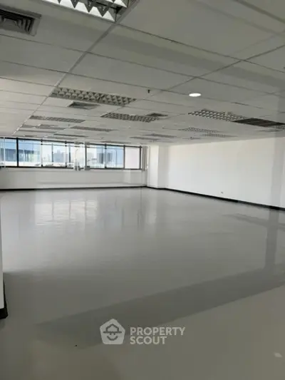 Expansive open-plan commercial space with abundant natural light, ideal for a bespoke office layout, featuring a reflective polished floor and drop ceiling.