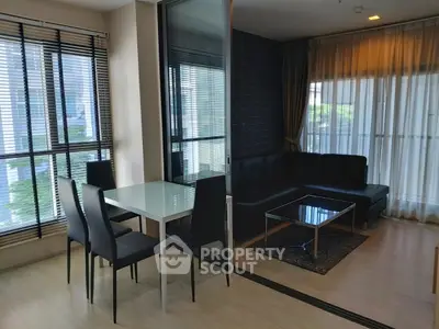 Modern living room with sleek dining area and large windows for natural light.