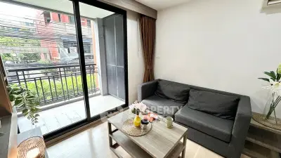 Modern living room with balcony access, featuring sleek furniture and natural light.