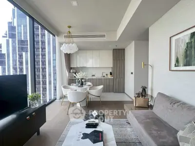 Modern living room with open kitchen and floor-to-ceiling windows in a high-rise apartment.