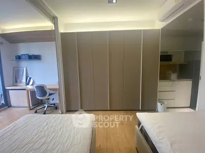 Modern bedroom with study area and built-in wardrobe, featuring sleek design and natural lighting.