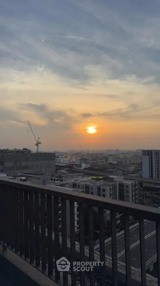 Stunning sunset view from a high-rise balcony overlooking the city skyline.