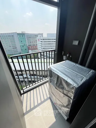 Modern balcony with city view and covered appliance, ideal for urban living.