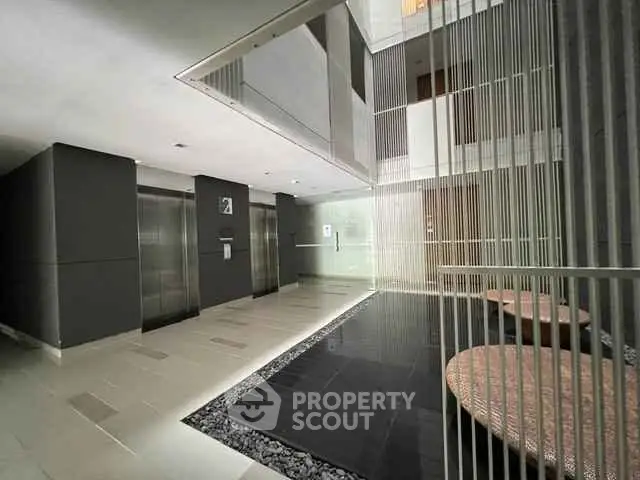 Modern building lobby with elevators and stylish seating area