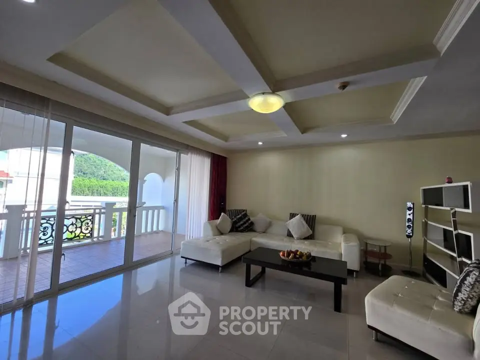 Spacious living room with elegant decor and large balcony offering scenic views.