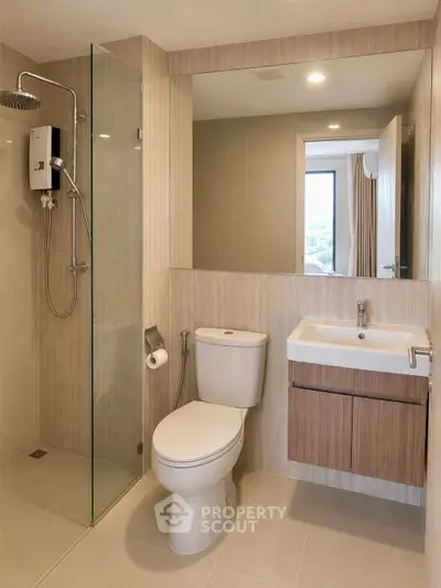 Modern bathroom with glass shower, sleek sink, and neutral tones.