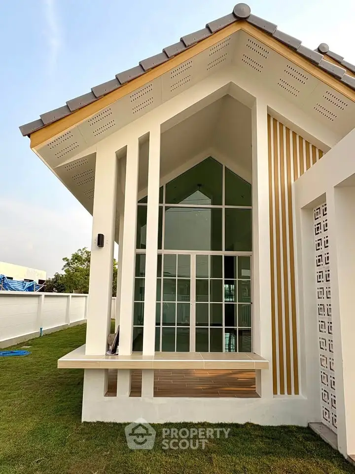 Modern architectural exterior with large windows and stylish design, showcasing contemporary real estate appeal.