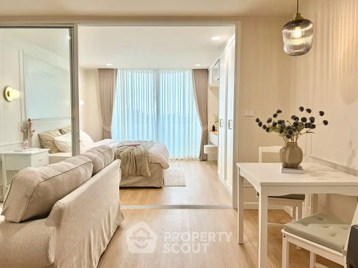 Modern open-plan living room and bedroom with elegant decor and natural light.