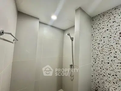 Modern bathroom with sleek shower and terrazzo wall design