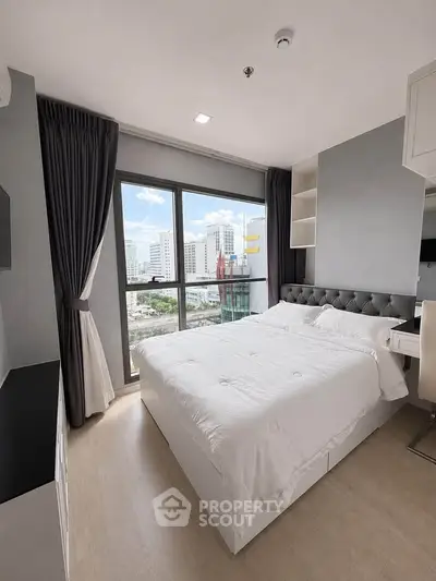Modern bedroom with city view, featuring a plush bed and elegant decor in a high-rise apartment.