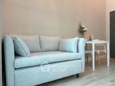 Cozy living room with modern gray sofa and elegant dining table, perfect for urban living.