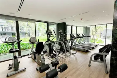 Modern gym with state-of-the-art equipment and garden view in luxury condo.