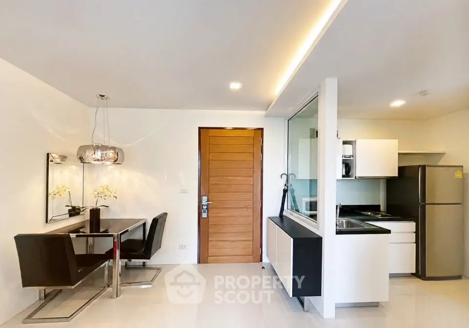 Modern open-layout kitchen and dining area with sleek design and contemporary lighting.