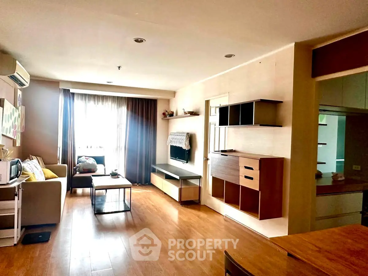 Spacious living room with modern decor and natural light in a stylish apartment.