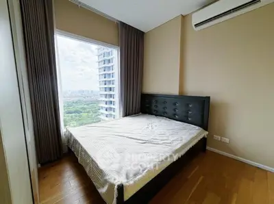 Modern bedroom with large window offering stunning city view and natural light.