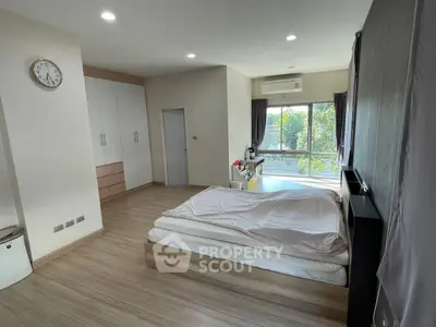 Spacious bedroom with large window and modern decor