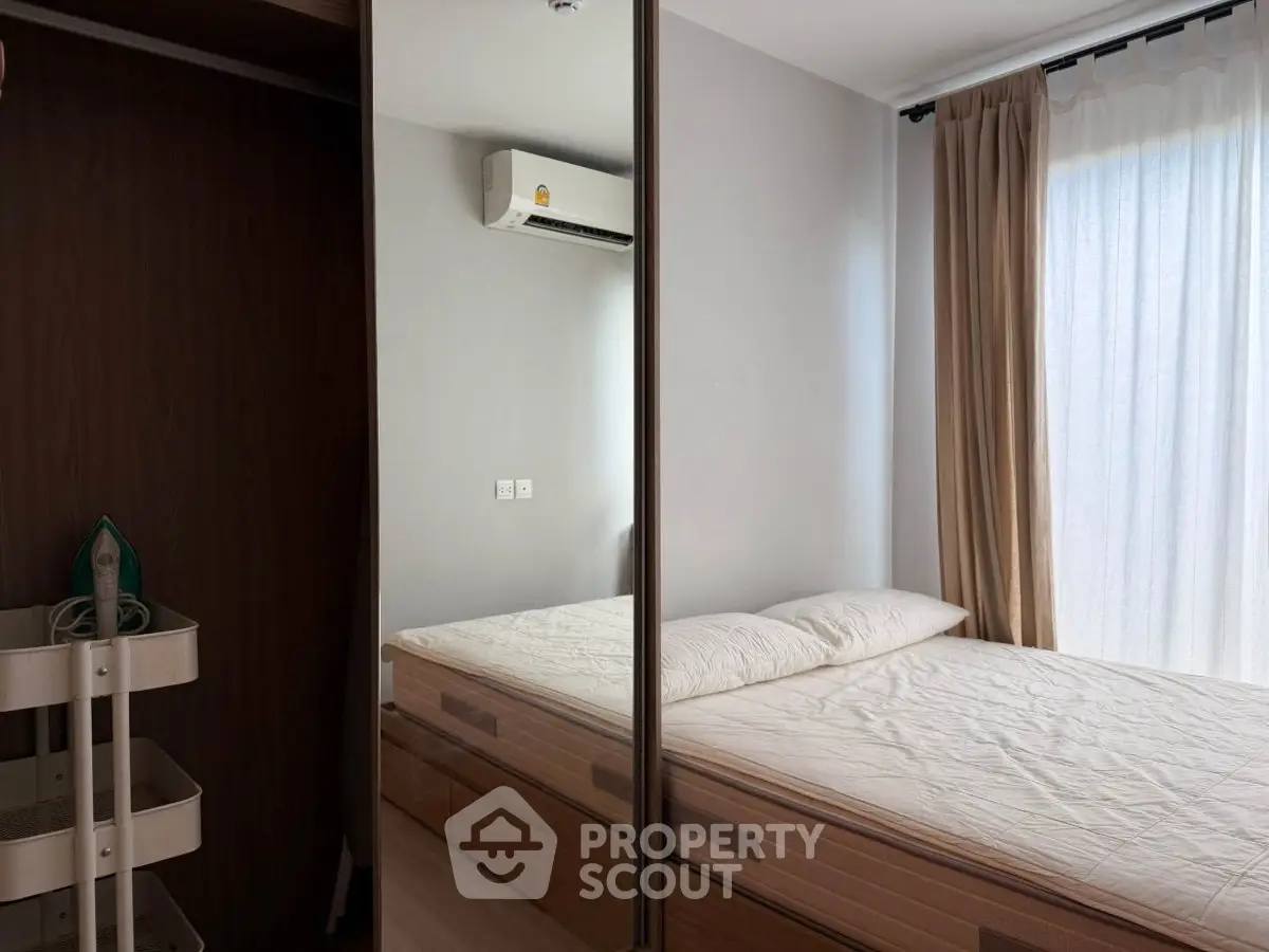 Modern bedroom with mirrored wardrobe and natural light
