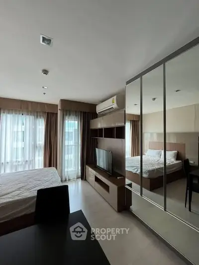 Modern bedroom with mirrored wardrobe and natural light in stylish apartment