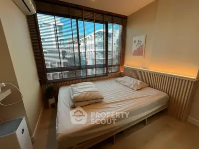 Cozy bedroom with large window and modern decor in urban apartment