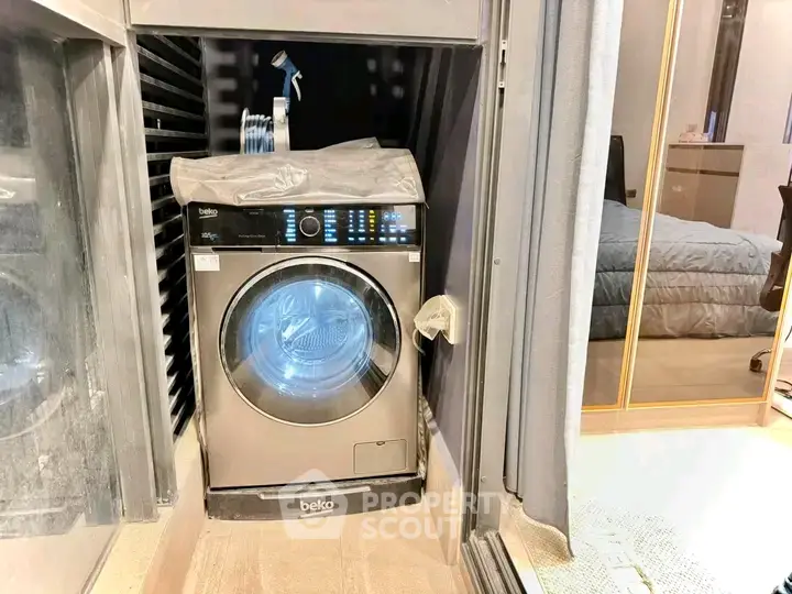 Modern apartment with built-in washing machine and cozy bedroom view.