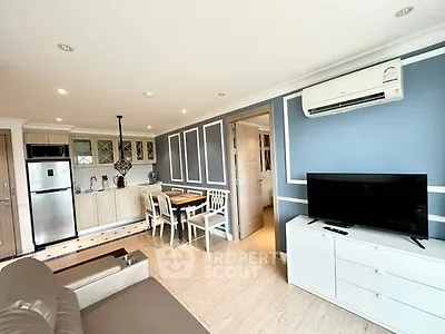 Modern open-plan living room with kitchen, featuring air conditioning and stylish decor.