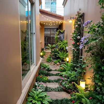 Charming garden pathway with lush greenery and ambient lighting in a cozy outdoor space.