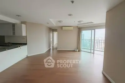 Spacious modern living room with open kitchen and balcony view