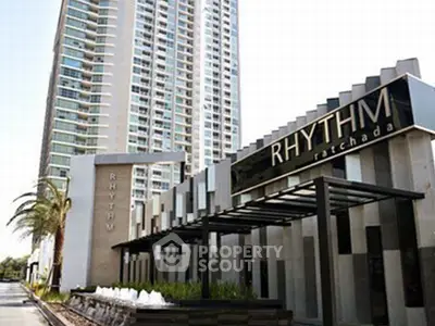 Modern high-rise building with sleek entrance at Rhythm Ratchada, showcasing urban living.
