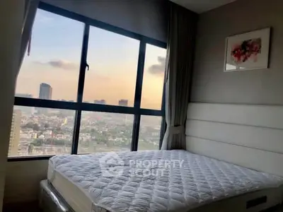 Cozy bedroom with stunning city view through large windows, featuring a comfortable bed and elegant decor.