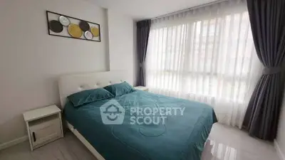 Modern bedroom with large window and stylish decor in a bright apartment.