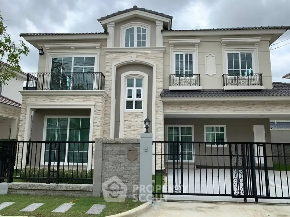 Elegant two-story house with modern facade and gated driveway