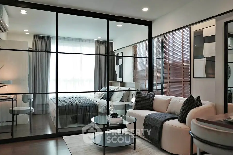 Modern studio apartment with glass partition, cozy living area, and stylish decor.