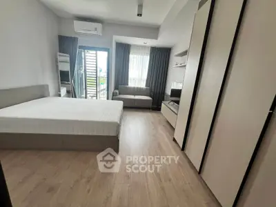 Spacious modern bedroom with balcony access and sleek furnishings