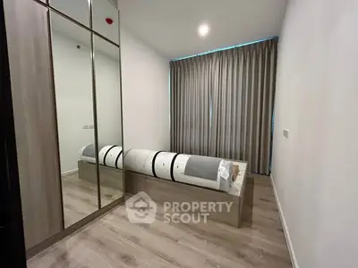 Modern minimalist bedroom with mirrored closet and sleek design