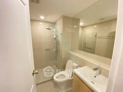 Modern bathroom with sleek fixtures and large mirror in a contemporary apartment.