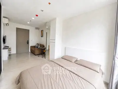 Spacious modern bedroom with minimalist decor and cozy seating area
