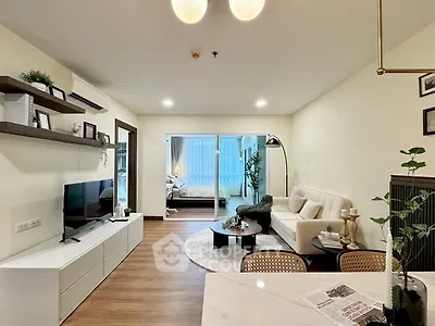 Modern living room with open layout and stylish decor, featuring a cozy seating area and elegant lighting.