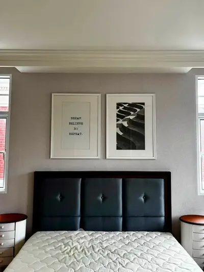 Stylish bedroom with modern decor and framed art above a sleek bed.