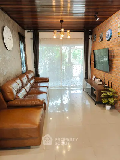 Stylish living room with leather sofa, modern decor, and large window for natural light.