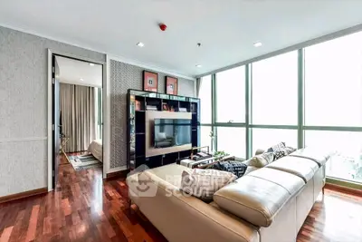Luxurious living room with large windows and modern decor in high-rise apartment.