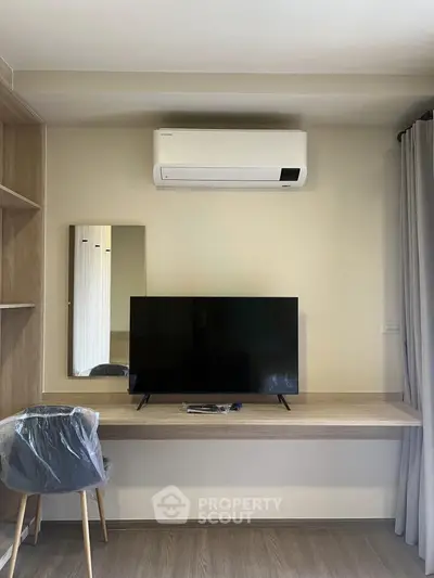 Modern study area with air conditioning and sleek TV setup in a stylish apartment.
