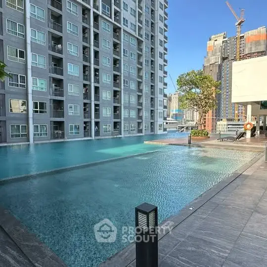 Modern high-rise building with luxurious pool and cityscape view.
