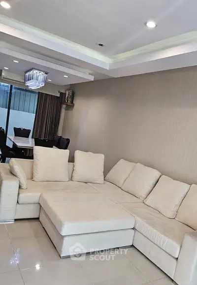 Spacious living room with modern L-shaped sofa and elegant dining area