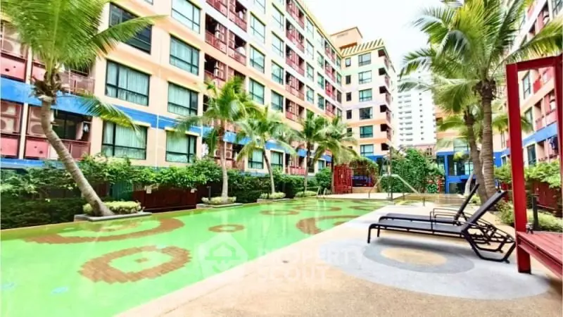 Luxurious apartment complex with vibrant pool and lush palm trees