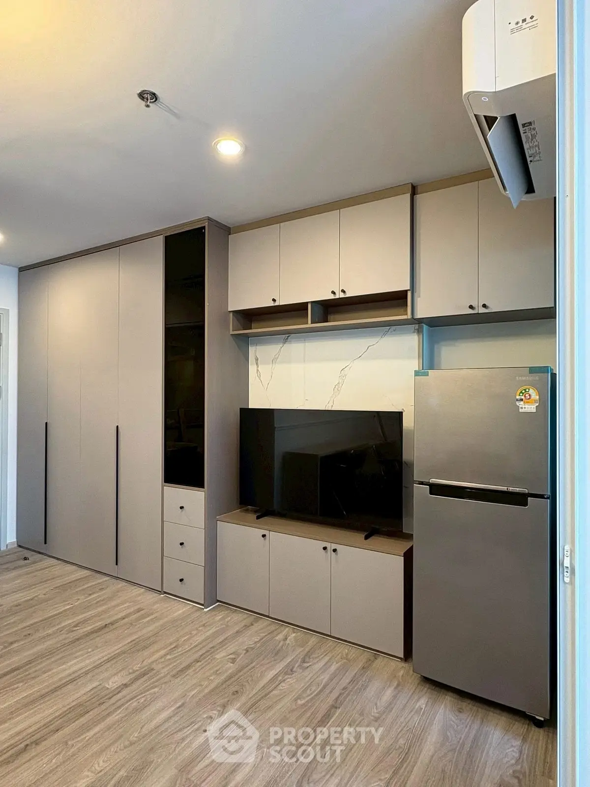 Modern living room with sleek cabinetry and stainless steel fridge, perfect for urban living.