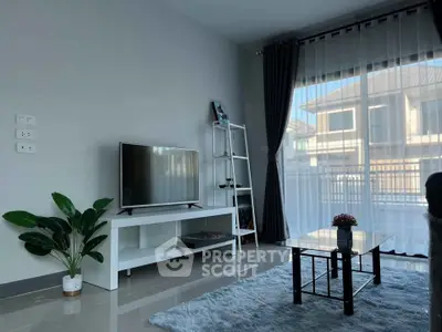 Modern living room with sleek TV setup and large window view