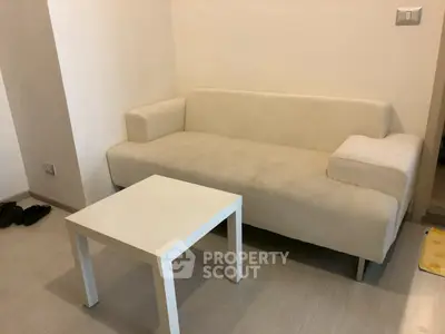 Cozy living room with modern white sofa and matching coffee table.