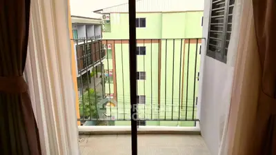 Charming balcony view with sliding glass doors and urban surroundings, perfect for city living.