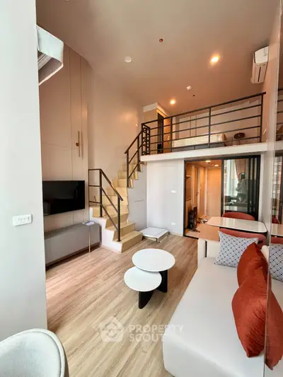 Modern loft-style living room with mezzanine, stylish furniture, and open layout in a contemporary apartment.
